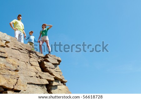 Portrait of family members looking afar outside while standing on cliff