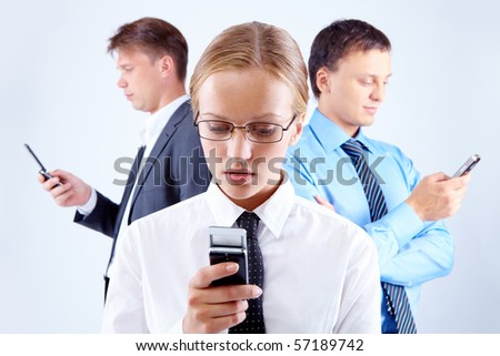 Portrait of serious businesswoman and two men with cellular phones