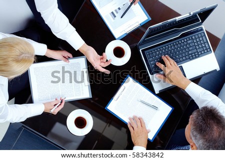 Image of partners hands during discussion of business plan at meeting