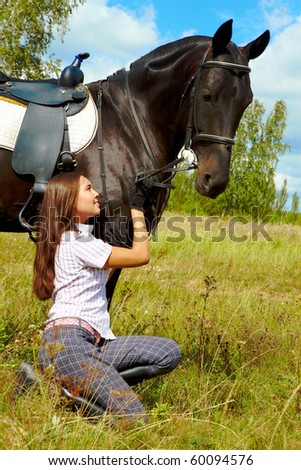 Image of happy female taking care of purebred horse outdoors