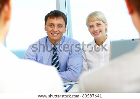Portrait of two business partners looking at their interviewees during conversation
