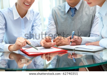 Image of business people sharing ideas round the table at meeting