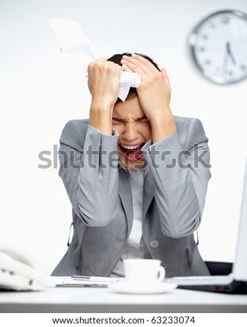 Image of young employer touching her head in frustration and crying at workplace