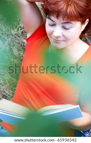 Portrait of middle aged female reading book in natural environment