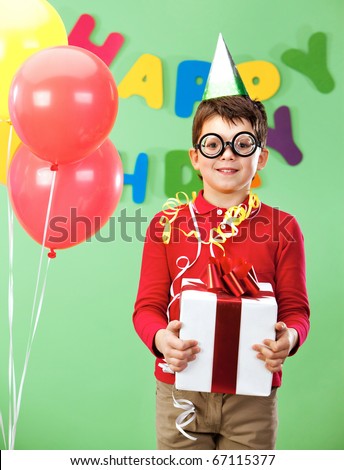 Portrait of happy lad in funny eyeglasses on birthday party with giftbox