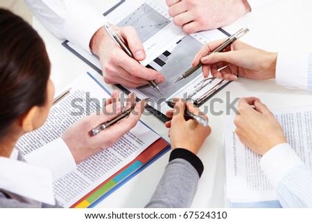 Image of human hands during discussion of business plan at meeting