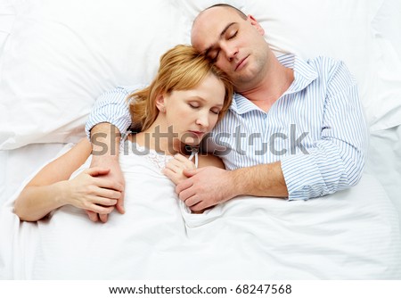 Photo of adult couple sleeping at night