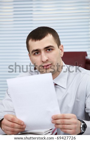Portrait of a serious manager holding document