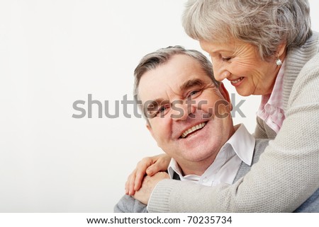 Portrait of careful wife embracing her husband over white background