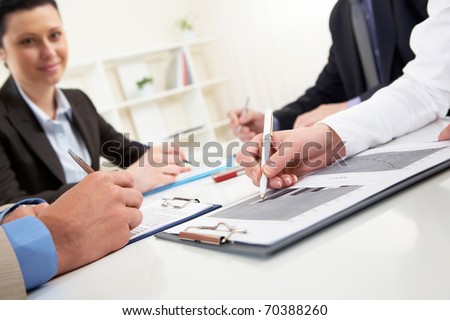Close-up of business person hand over document in working environment