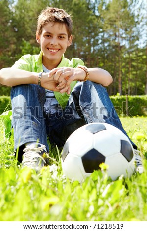 Portrait of happy lads with ball near by looking at camera