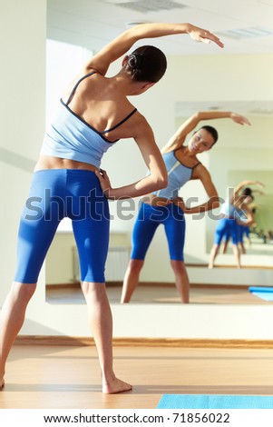 Portrait of young sporty girl doing physical exercise