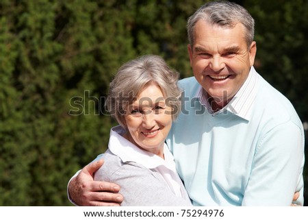Portrait of happy senior couple embracing each other and looking at camera