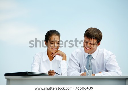 Portrait of man and woman sitting at the desk and interacting with each other