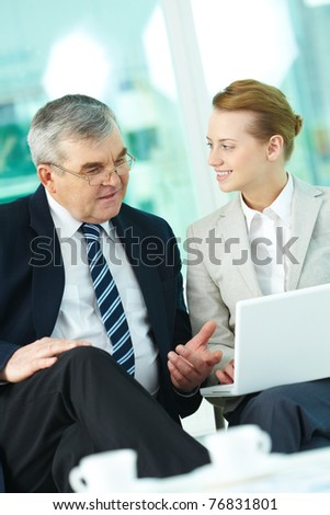 Portrait of boss and employee working with laptop in office