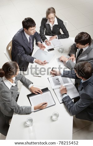 Team of five business people discussing an important question at briefing