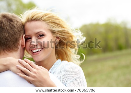 Portrait of happy girl hugging her boyfriend outside