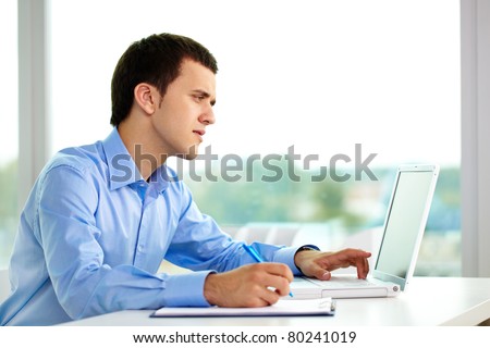 Portrait of successful businessman working on computer in office