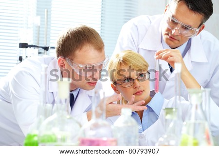 Three chemists researching liquid in tubing