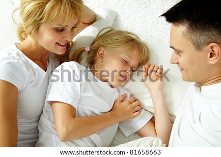 Portrait of calm girl sleeping while parents looking at her