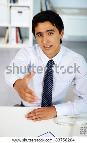 Portrait of a successful employer looking at camera while giving his hand for handshake