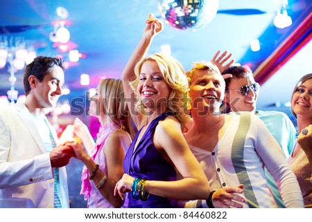 Portrait of cheerful girls and guys dancing at party
