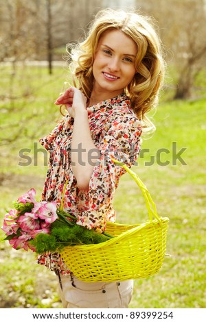 Girl holding a basket with flowers and looking at camera
