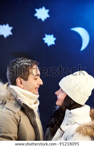 Portrait of happy couple looking at one another with moon and stars above their heads