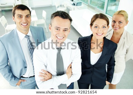 Portrait of business partners looking at camera with their leader in front
