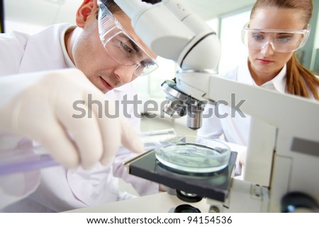 Similar – Image, Stock Photo Serious clinician studying chemical element in laboratory