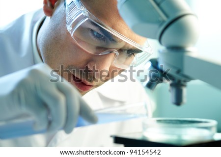 Image, Stock Photo Serious clinician studying chemical element in laboratory