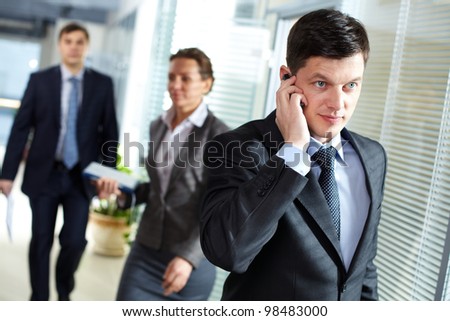 A handsome businessman calling by the phone in office