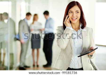 Business lady answering the phone with a smile, receiving good news