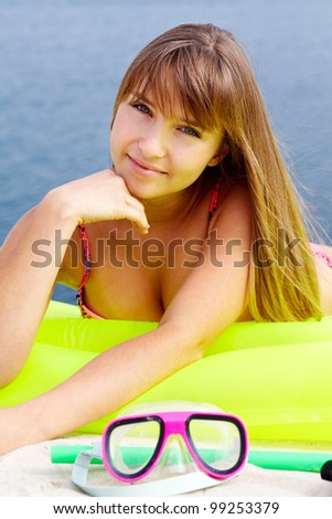 Pretty teenage girl lying on an air bed and looking at camera with a smile