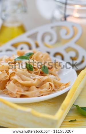 Pasta with red pesto sauce with fresh basil