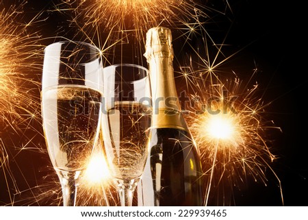 Happy new year, champagne with sparklers on dark background