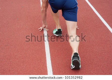 Runner on an athletic field waits for his start