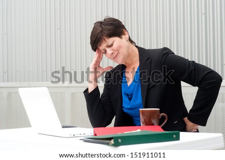 businesswoman under stress, fatigue, and headache at office
