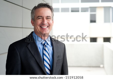 portrait of a confident mature businessman standing outside