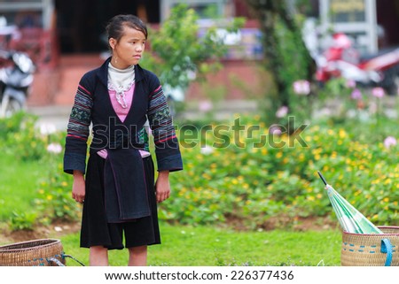 SAPA, VIETNAM Jul 04 2012: Black Hmong girl on the main street on July 4, 2012 in Sapa, Vietnam. Black Hmongs are the biggest ethnic minority in north Vietnam , especially in Sapa area