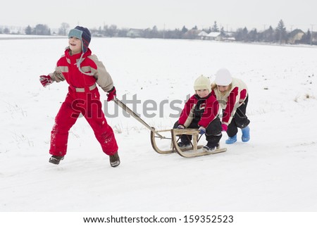 Children makes winter fun with sledge outdoor