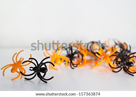 Black and orange plastic toy spider rings on white background