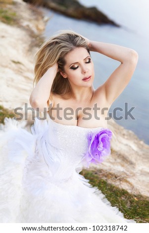 young beautiful bride in wedding dress at the beach at sunset spring summer day. Sexy romantic woman at sea shore