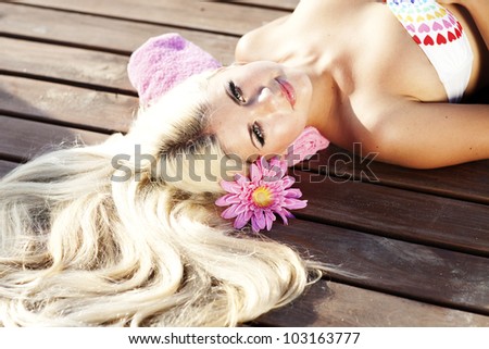 Slim girl resting at the beach - happy woman enjoying summer sun. Romantic woman dreaming at vacation holidays . Beautiful bikini model in swimwear at exotic spa resort