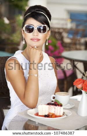 vintage beautiful woman in restaurant cafe with tiramisu cake and coffee.Healthy food  drink for breakfast.Stylish rich slim girl in retro dress.glamorous lady at vacation. Retro style.France.series