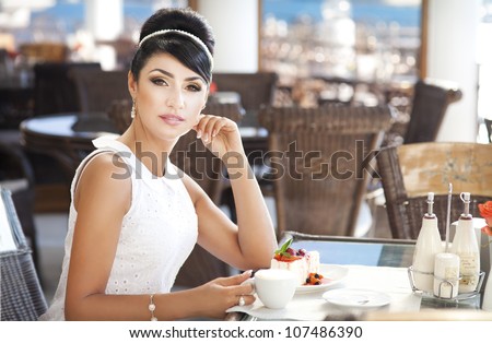 vintage beautiful woman in restaurant cafe with tiramisu cake and coffee.Healthy food  drink for breakfast.Stylish rich slim girl in retro dress.glamorous lady at vacation. Retro style.France.series