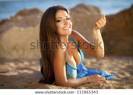 woman belly dancer on rock beach. dancing beautiful slim girl. sexy arabian turkish oriental professional artist in carnival blue costume and diamond jewelry outdoor. exotic bellydance star. Series