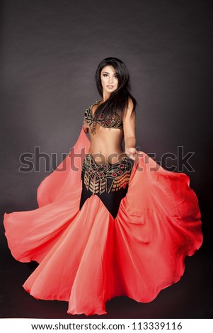 beautiful slim woman belly dancer. sexy arabian oriental professional artist in carnival shining costume with long healthy glossy hair. exotic star of bellydance. dancing girl brunette