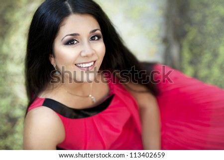 happy young smiling woman posing in autumn park. beautiful girl in stylish red dress relaxing on nature. gorgeous brunette romantic  lady resting and waiting for someone outdoor. positively thinking.