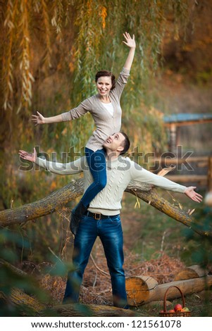 playful young couple in love having fun enjoy a moment of happiness on nature. handsome guy and beautiful brunette woman enjoying spring holiday together. Loving couple on date in park looking happy